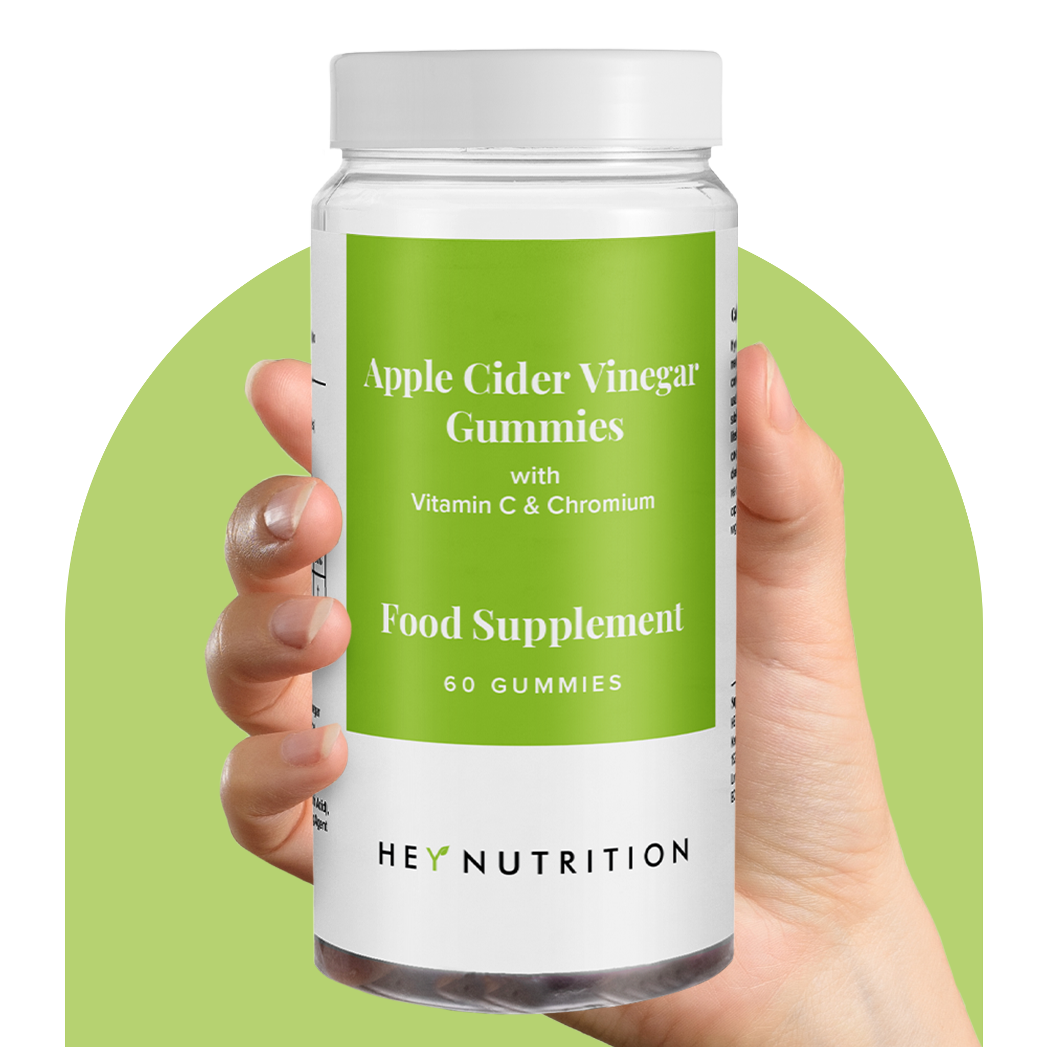 A hand holding a Hey Nutrition Apple Cider Vinegar Gummies bottle with a green label against a green circular backdrop.