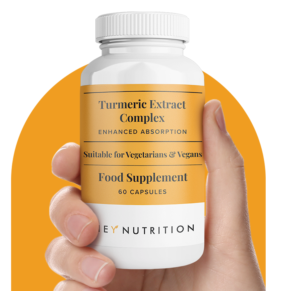 Hand holding a Hey Nutrition Turmeric Extract Complex bottle with orange background. Label text: "Turmeric Extract Complex – Enhanced Absorption. Suitable for Vegetarians & Vegans. Food Supplement. 60 Capsules."