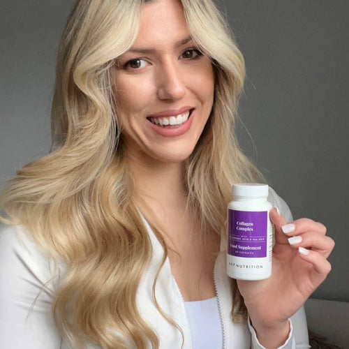 Woman with long blonde hair smiling and holding Hey Nutrition Collagen Complex food supplement with hyaluronic acid and sea kelp, 60 capsules.