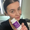 Woman indoors holding a bottle of Hey Nutrition Collagen Complex food supplement with hyaluronic acid and sea kelp, 60 capsules, close to her face.